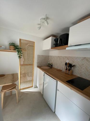 a kitchen with white cabinets and a counter top at Studio cosy avec cour privative in Bourg-Saint-Andéol