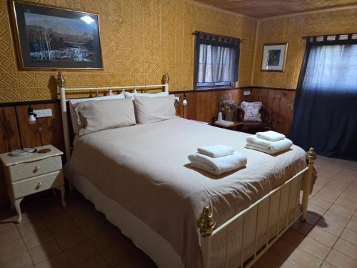 una camera da letto con un grande letto con asciugamani di LeVar - Rustic style accommodation with Ensuite and Mod Cons a Hoddy Well