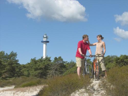 two men standing next to a bike on a hill at Apple Blossom Studio - near Rønne and Beach in Rønne