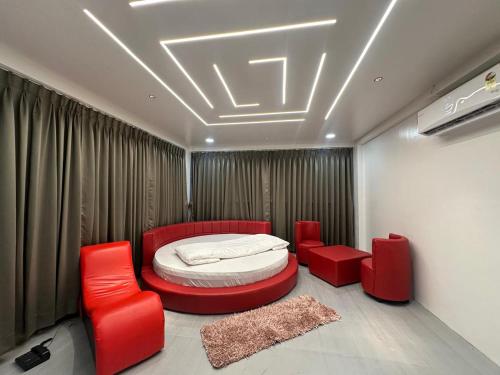 a bedroom with a bed and two red chairs at Hotel Hill Top Inn -Near Baner Rd Pune in Pune