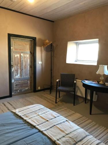 a bedroom with a bed and a table and a chair at Marsjövägen 17 in Borgholm