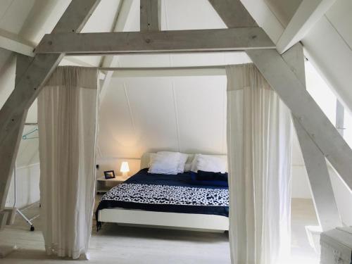 - une chambre avec un lit à baldaquin blanc dans l'établissement Les Volets Bleus, family cottage, à Crégols