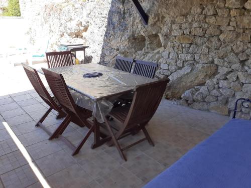 une table et des chaises en bois sur une terrasse dans l'établissement Les Volets Bleus, family cottage, à Crégols