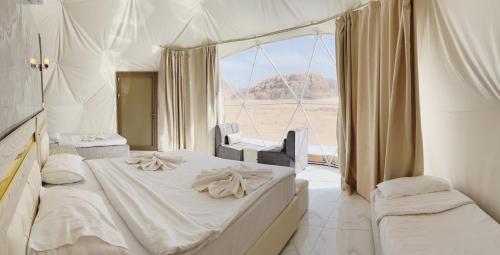 a bedroom with a bed and a large window at Rum Star Desert Camp in Wadi Rum
