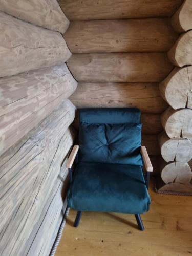 a chair sitting in front of a wall at Cabana dintre brazi Mărișel in Mărişel