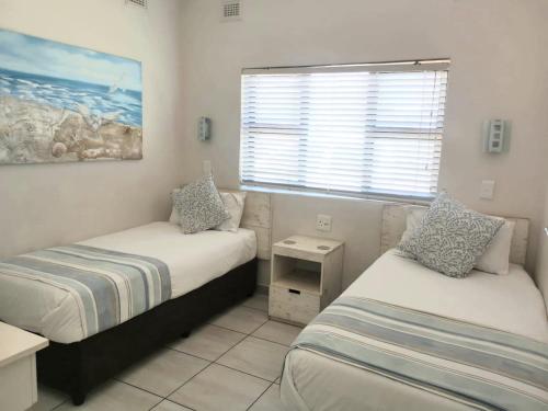 een kleine slaapkamer met twee bedden en een raam bij Banana Beach B4 in Melville