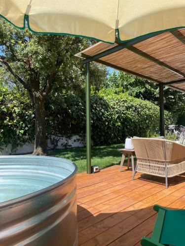 a hot tub on a wooden deck with an umbrella at Lunavi in Forte dei Marmi