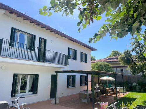 a white house with black windows and a patio at Lunavi in Forte dei Marmi