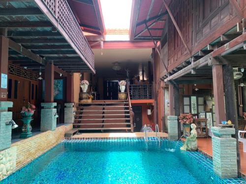 a swimming pool in the middle of a house at Ruennakornin Homestay in Ban Bang Muang