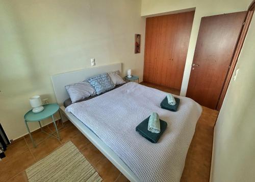 a bedroom with a bed with two hats on it at Pelagos Apartments in Myrtos