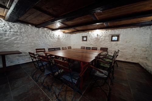 a room with a wooden table and chairs at Abásfalvi Vendégházak in Aldea