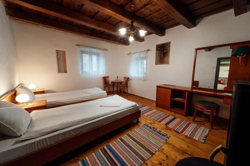 a bedroom with a bed and a desk and a mirror at Abásfalvi Vendégházak in Aldea