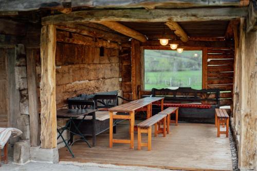 a room with tables and chairs in a log cabin at Abásfalvi Vendégházak in Aldea