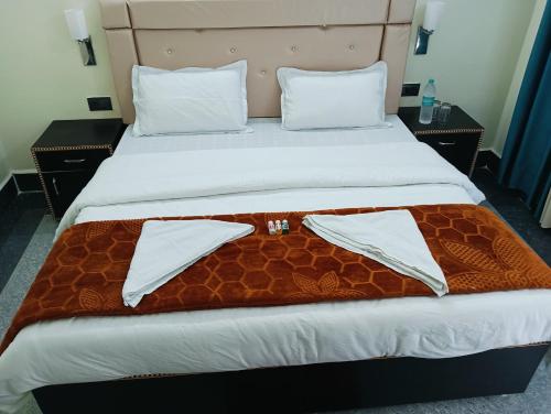 a bed with a brown and white blanket on it at Hotel HBH Himalaya's Beautiful Hills in Uttarkāshi