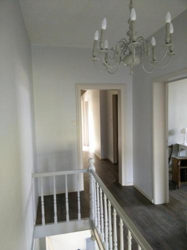 a staircase in a house with a chandelier at Gite la Blanche in Ogy