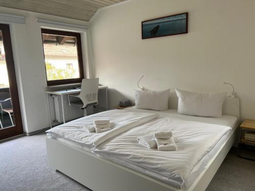 a bedroom with a white bed with two towels on it at Apartment BERGfamilie - gemütlich ausgestattet, ruhig und familienfreundlich in Schliersee