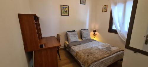 Un dormitorio pequeño con una cama y un escritorio. en Mangue-carotte, en Saint-Denis
