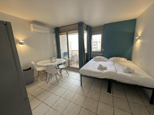 a bedroom with a bed and a table with chairs at Résidence Graziella Studio 308 in Juan-les-Pins