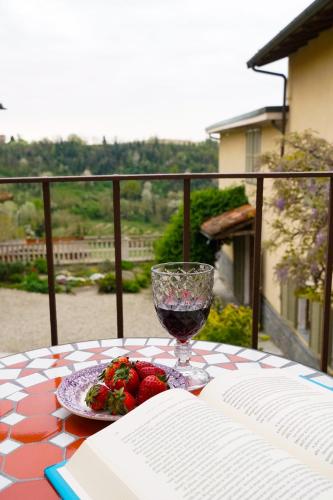 a glass of wine and a plate of fruit on a table at Ca' del Borgo in Vignale Monferrato