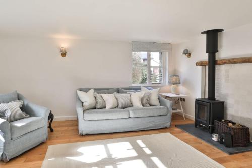 a living room with a couch and a fireplace at *New* Tranquil Countryside Luxury Barn Conversion in Georgeham