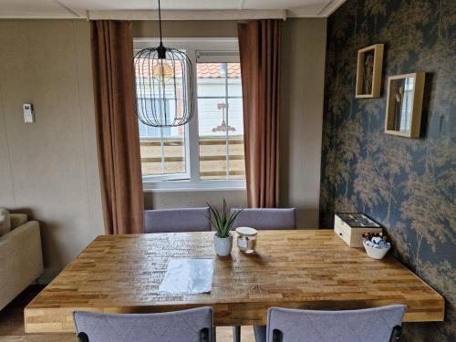 a dining room with a wooden table and chairs at Chalet 'De Bosrand' in Anloo