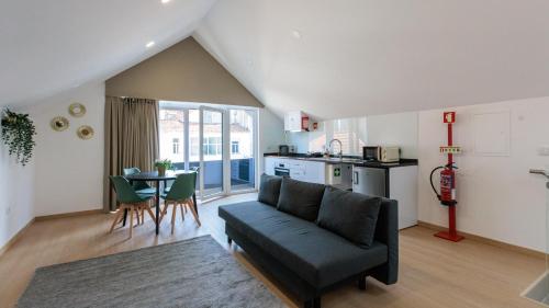 a living room with a couch and a table and a kitchen at Live in Aveiro Beira Mar in Aveiro
