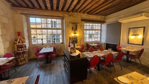 a restaurant with tables and chairs in a room at Logis Hôtel Restaurant Le Puits Doré in Richelieu