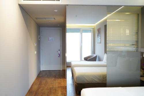 a hotel room with two beds and a couch at Bougainville Bay Hotel in Sarandë
