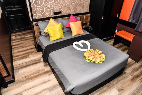 a bed with colorful pillows and a heart on it at The Beehive in Male City