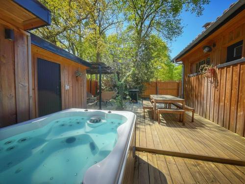 ラントンにあるLa Cabanarêve Plage Spa pour 6 personnesのホットタブ(ピクニックテーブル付きのデッキあり)