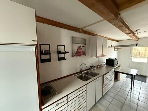 a kitchen with a sink and a table in it at Lejlighed på Tåsinge ved Svendborg in Svendborg