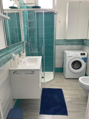 a bathroom with a sink and a washing machine at Cozy Corner Apartment Forio in Forio d'Ischia