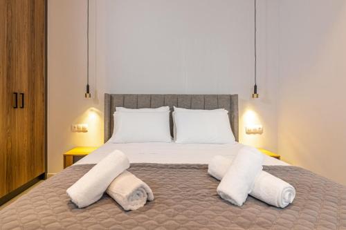 een slaapkamer met een bed met twee handdoeken erop bij Lume, Stylish New Apartment Near the Beach in Agia Pelagia