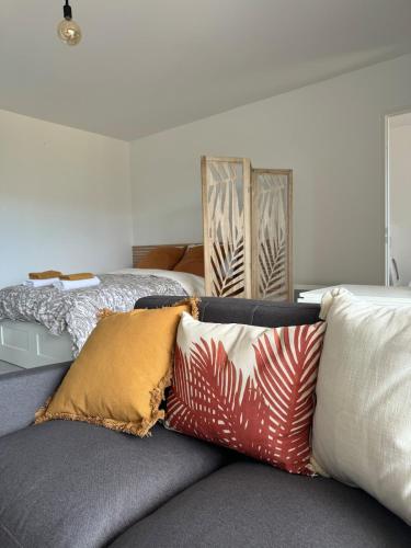 - un salon avec un canapé et des oreillers dans l'établissement Appartement cozy proche du centre Terrasse,Parking, à Montpellier