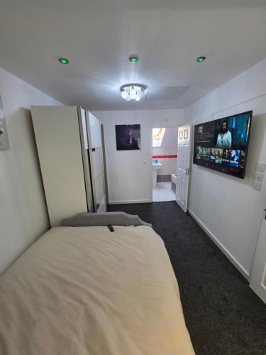a bedroom with a bed and a flat screen tv at Very cosy 3 bedroom house close to city in Longford
