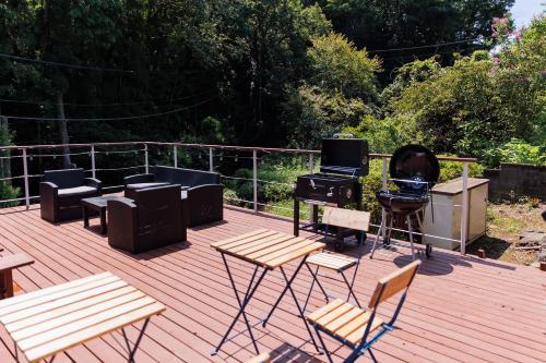 a deck with a group of furniture and a grill at to dream in Ito