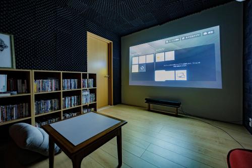 a room with a large screen in a library at to dream in Ito