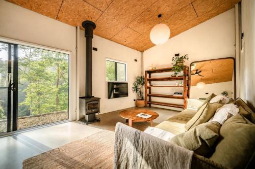 a living room with a couch and a fireplace at Off-Grid Eco Cabin in Bellingen
