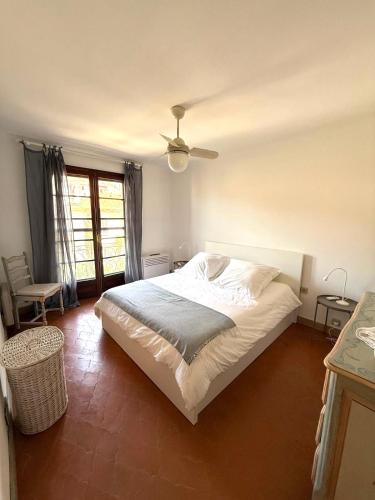une chambre avec un lit et un ventilateur de plafond dans l'établissement Appartamento in Saint Tropez centro di 2 locali con aria condizionata Wi-Fi e disponibilità parcheggio, à Saint-Tropez