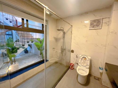 a bathroom with a toilet and a shower and a window at BON villa TAM ĐẢO in Tam Ðảo