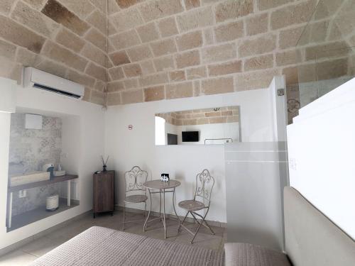 een kamer met een tafel en stoelen en een bakstenen muur bij Matilde Home in Monopoli