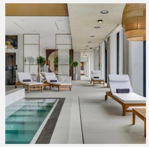 eine Lobby mit Stühlen und einem Pool in einem Gebäude in der Unterkunft Baltic Riviera Apartments -Solmarina in Wiślinka