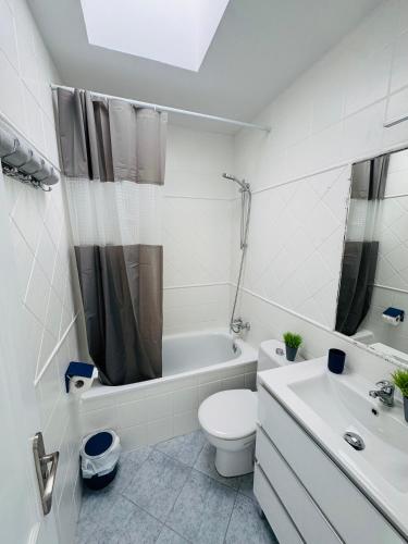 a white bathroom with a toilet and a sink at Bungalow Simone in Maspalomas