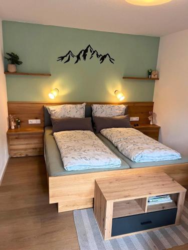 a bedroom with a large bed with a wooden frame at Ferienwohnung Bergleuchten in Obermaiselstein