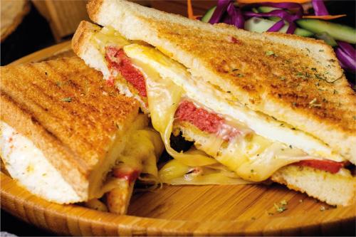 a sandwich cut in half on a wooden plate at La Casa in Paese in Peschiera del Garda