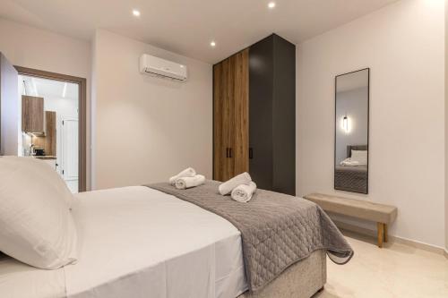 Un dormitorio con una cama grande con dos toallas. en Terra, Stylish New Apartment Near the Beach, en Agia Pelagia