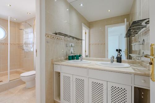 a bathroom with two sinks and a toilet at Townhouse Park Paraiso in Adeje