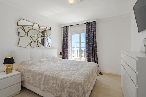 a white bedroom with a bed and a window at Townhouse Park Paraiso in Adeje