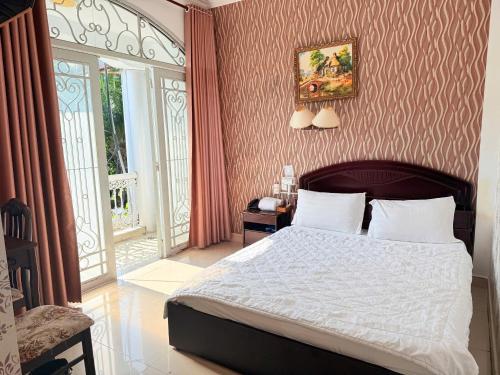 a bedroom with a large bed and a window at Hong Tam Hotel in Ho Chi Minh City