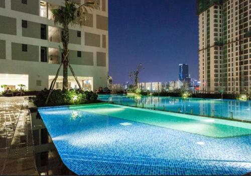 a large swimming pool in a city at night at RiverGate Residence in Ho Chi Minh City